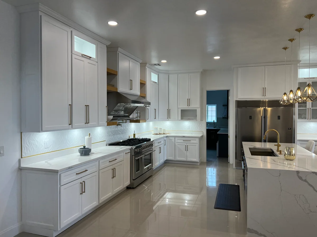Black & Brass kitchen with white cabinetry, dark island, view 3