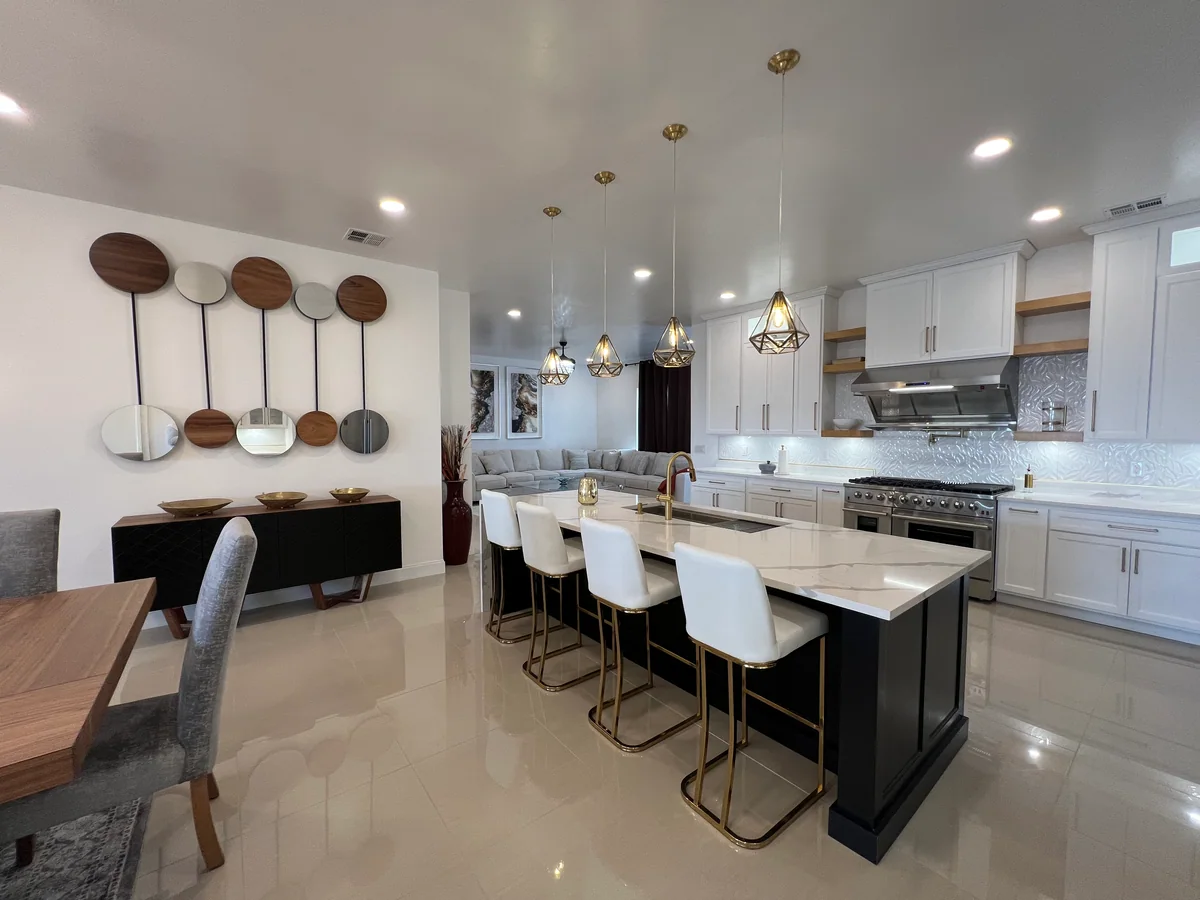 Black & Brass kitchen with white cabinetry, dark island, view 1
