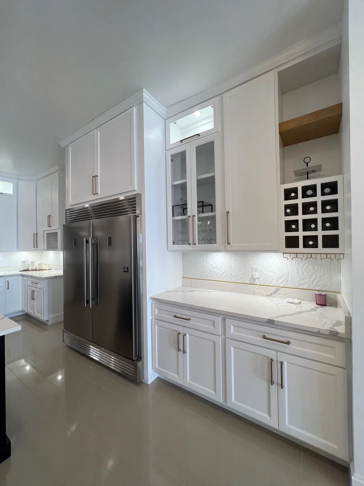 White beverage cabinetry with glass doors and bottle storage