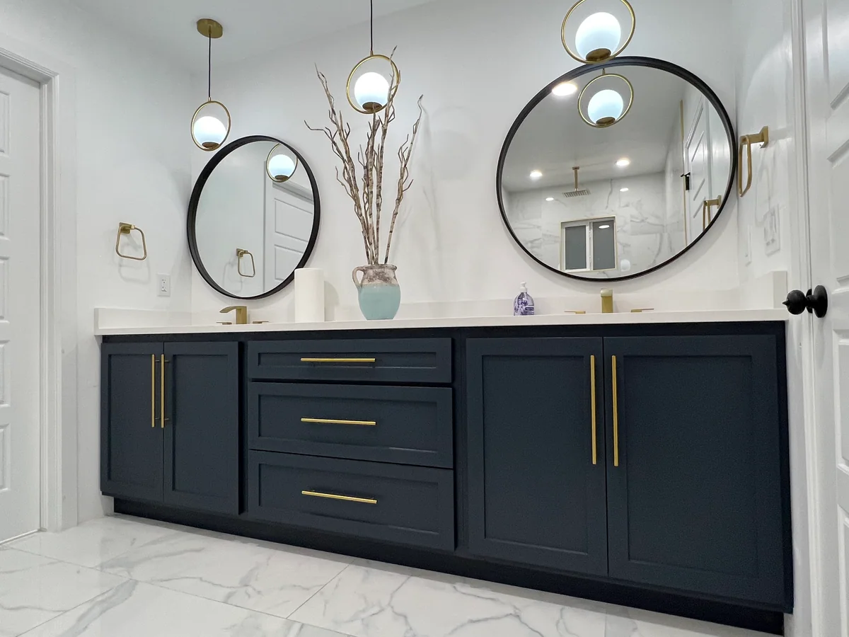 Deep blue double vanity with brass hardware and round mirrors
