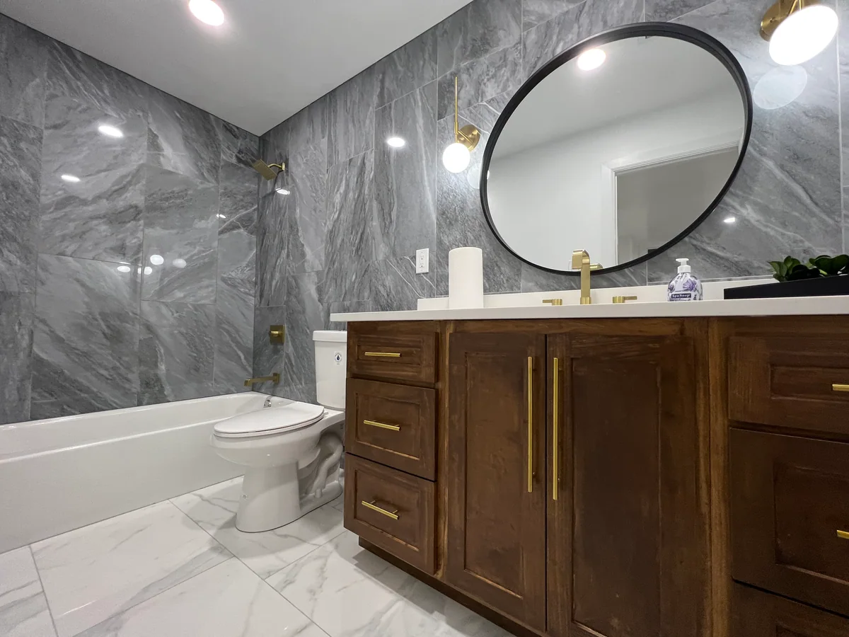 Wood bathroom vanity with a round mirror