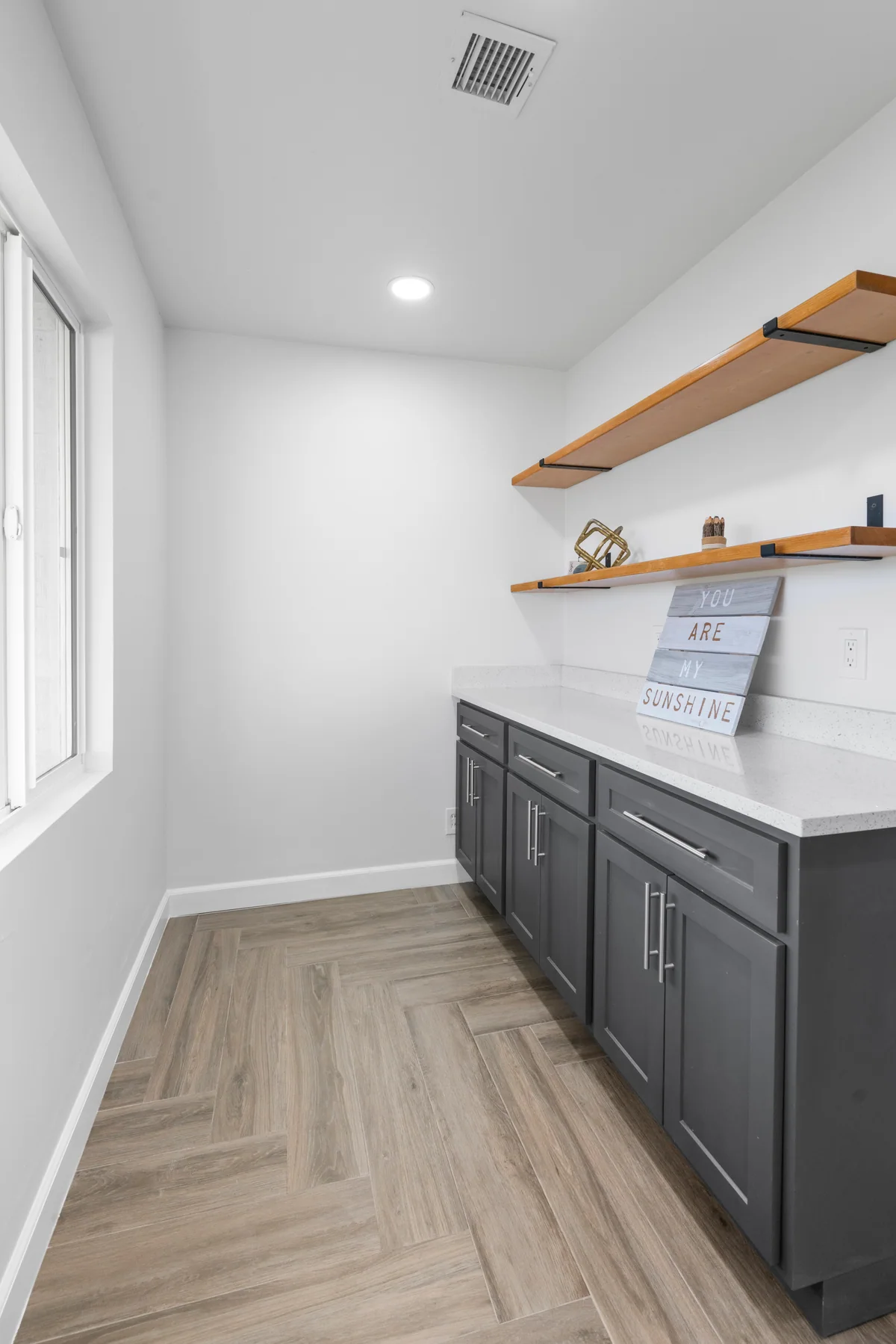 Gray pantry cabinetry with floating wood shelves