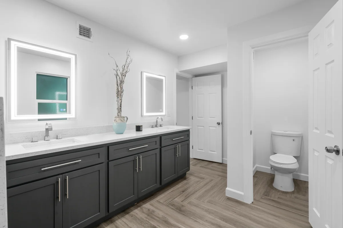 Gray double vanity with illuminated mirrors