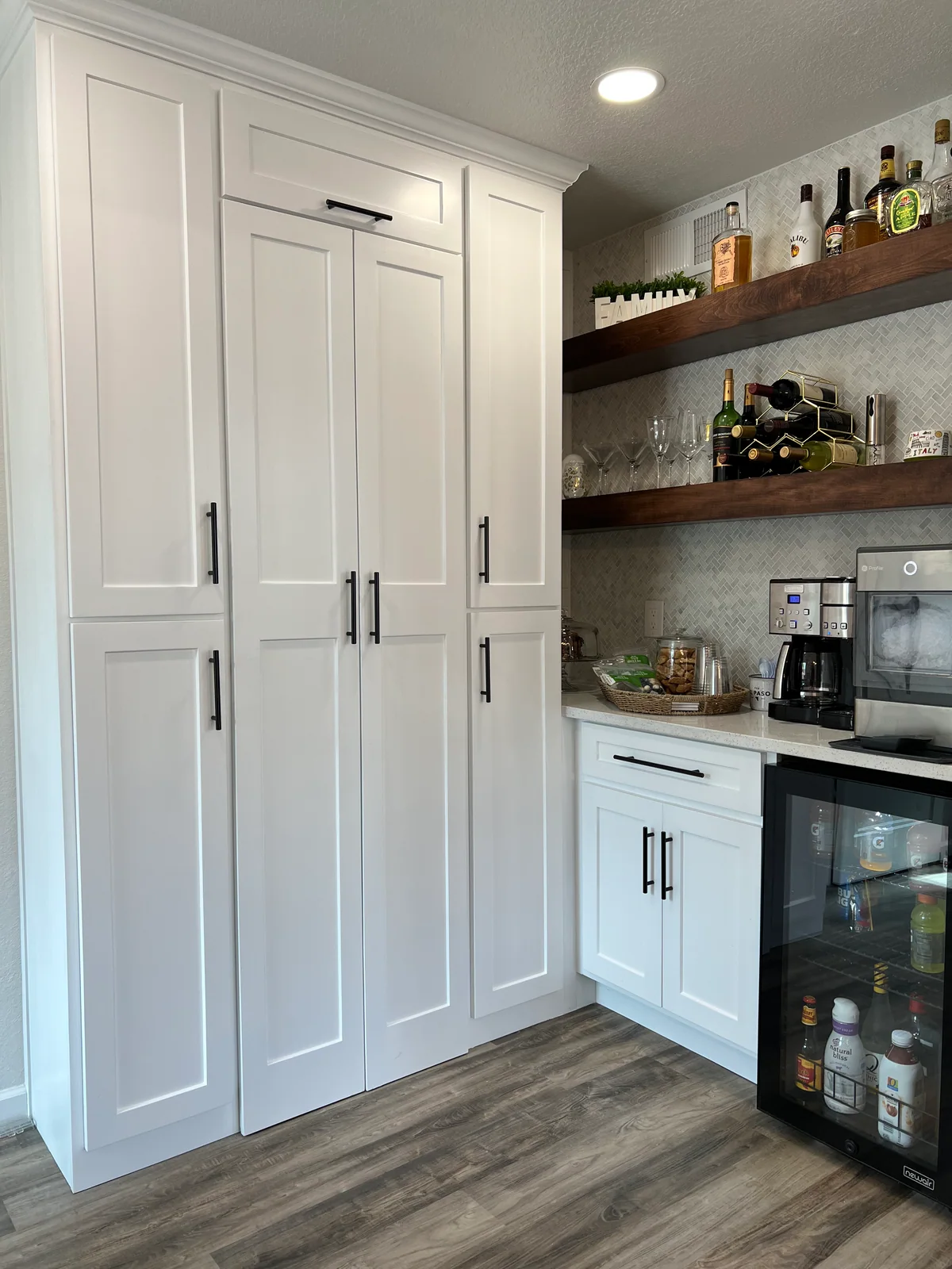 Tall white pantry cabinets beside open wood shelves