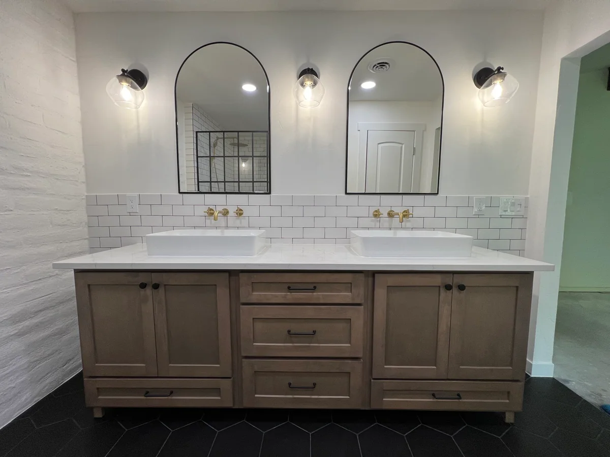 Wood double vanity beneath arched mirrors