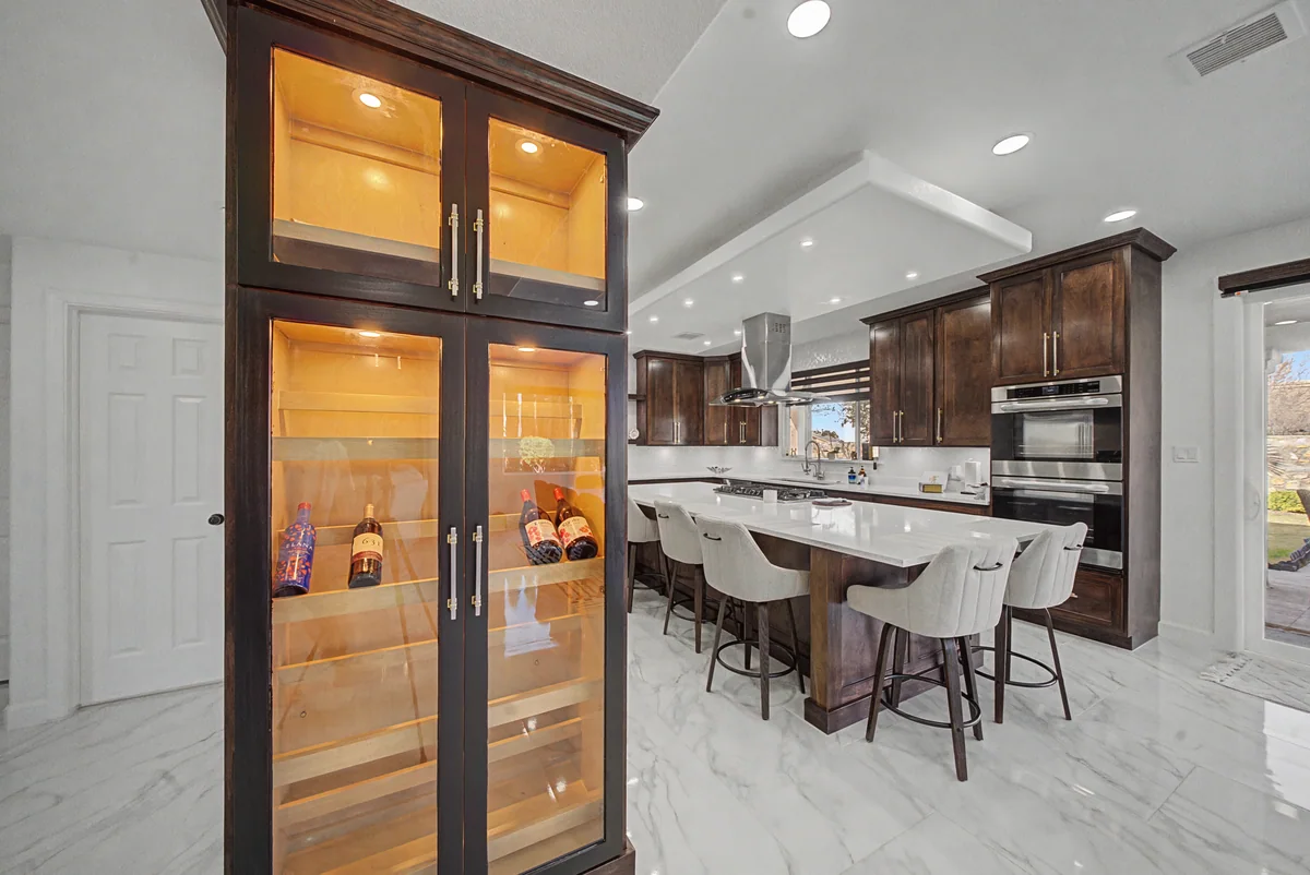 Warm Heritage kitchen with wood cabinetry, lighted glass cabinets, view 2