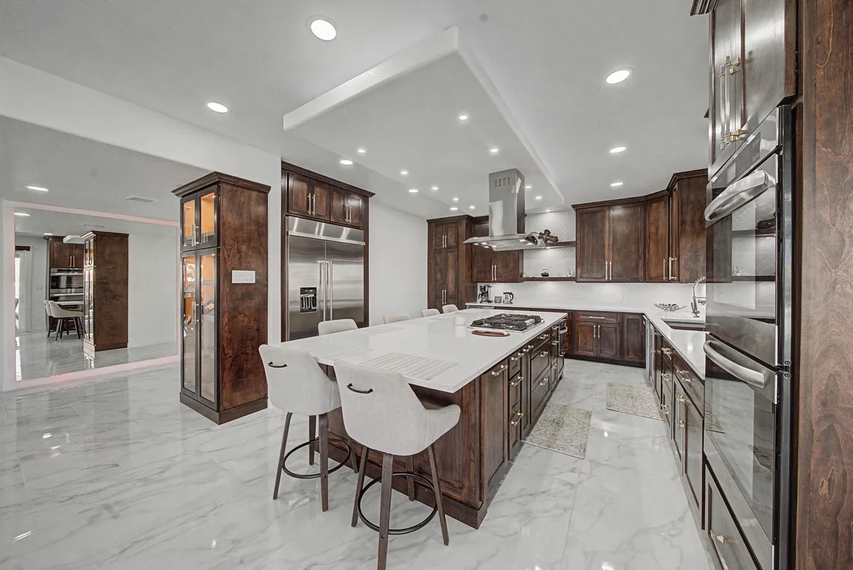 Warm Heritage kitchen with wood cabinetry, lighted glass cabinets, view 3